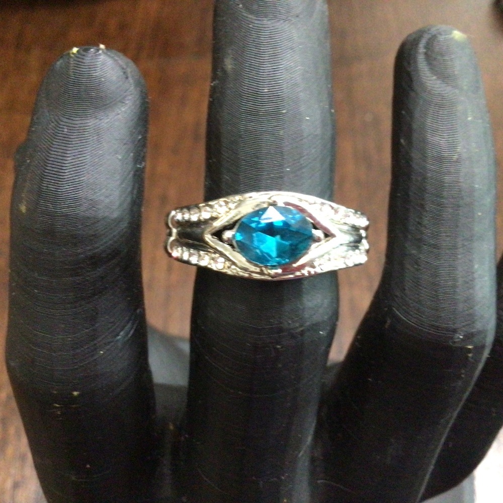 Stretchy ring with aqua colored stone, surrounded by clear rhinestones